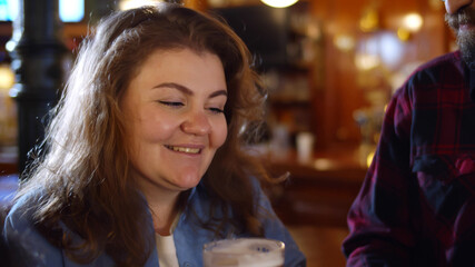 Friends in pub drinking beer, talking and having fun.