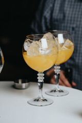 Cocktails with champagne in wine glasses on the bar table in the pub or restaurant with the bartender.