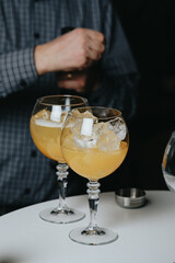 Cocktails with champagne in wine glasses on the bar table in the pub or restaurant with the bartender.