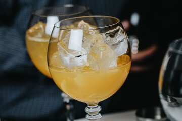 Cocktails with champagne in wine glasses on the bar table in the pub or restaurant with the bartender.