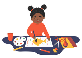 Kids' crafting. Child paints and cuts paper. Little african girl makes crafts. Children' creativity and imagination development playing concept.