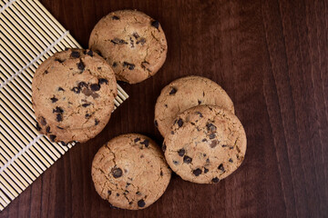 Chocolate chip cookies on a wooden background top view stock images. Sweet chocolate cookies on the table images. American sweet biscuits photo. Cookies on a wooden background with copy space for text