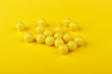 Yellow vitamin C capsules spilled out Yellow background. Take care of your health. Vitamins and minerals. Free space