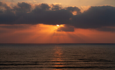Sunset over the sea. Sunrays and waves
