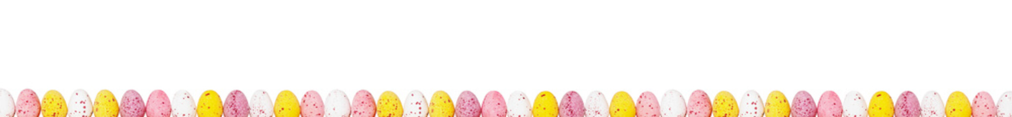 Amazing easter border with small colourful eggs isolated on white. Panorama paint eggs. Yellow, pink, white eggs in easter composition.