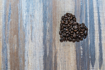 Heart symbol made of coffee beans on a wooden surface. Welcoming the day of love, February 14, Valentine Day.