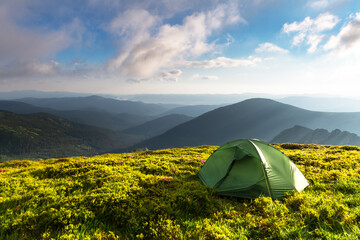 Green tent on amazing meadow in spring mountains. Landscape photography, travel concept © Ivan Kmit