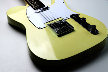 Yellow colored vintage electric guitar on white background - close up