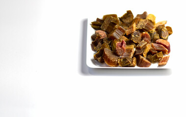 Candied rhubarb on a white background. Dry rhubarb close - up macro photography. Rheum. Dried rhubarb candied fruits