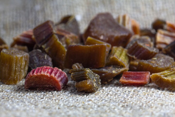 Dried rhubarb candied fruits. Candied rhubarb on a canvas fabric background. Dry rhubarb close - up macro photography. Rheum.