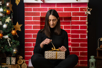 Young woman opening christmas present