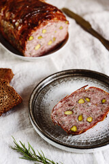 Terrine. Meatloaf. Traditional French cuisine loaf of meat, similar to a pâté, with bacon and pistachios. Selective focus