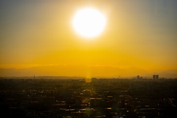 冬の東京の夕暮れの街並みと巨大な夕日