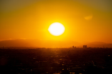 冬の東京の夕暮れの街並みと巨大な夕日