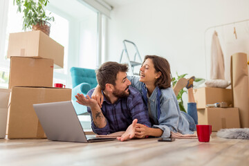 Couple searching the web for apartment renovation ideas while moving in together