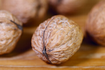 Food background. Walnut close-up. Round whole walnuts lie on a wooden table.