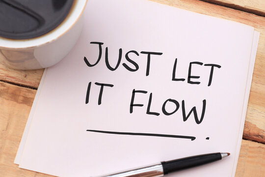 Just let it flow, text words typography written on paper against wooden background, life and business motivational inspirational
