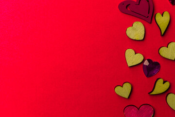 Valentine's day background from wooden and crystal hearts on a red backdrop. Copy space. Love and wedding concept