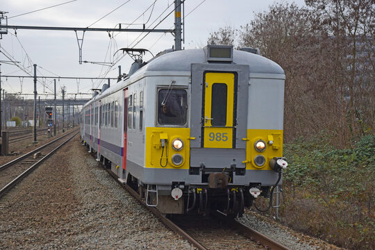 Old Belgian White and Yellow NMBS-SNCB InterCity Train on a Railway Line. Classical EMU of the Belgian National Railway Company in Vilvoorde, Belgium