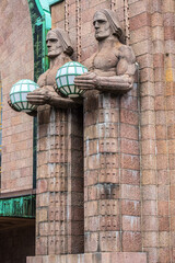 Architectural fragments of Helsinki Central railway station (Rautatieasema) with neo classical clock tower and figures holding lamps. Helsinki. Finland.