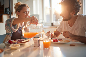 Happy couple having breakfast together - obrazy, fototapety, plakaty