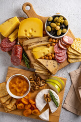 Different types of cheeses  and cold cut meats. Top view on a white background. Assorted cheeses with nuts, cracker,  olives, salami  and rosemary.