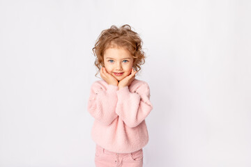 little baby girl in pink winter clothes on white background rejoices, space for text