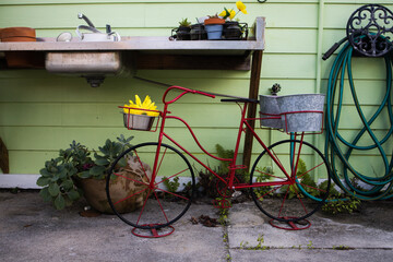 Red Metal Bike Decor in Front of Potting Bench and Plants