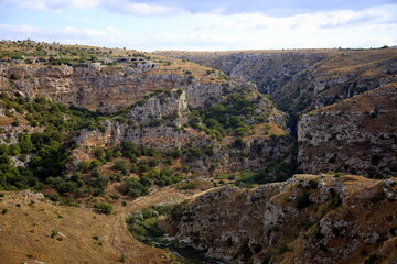 Fototapeta na wymiar View of the gorge of the Gravina stream and the rocky walls in the park of the Murgia of Matera, European Capital of Culture 2019
