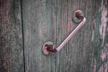 An old rusty doorknob on a wooden door
