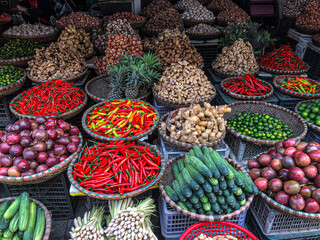 Hanoi, Vietnam, January 30, 2020 - View on a seller in the middle of a large assortment of row loose vegetables and fruits for sale in a street. Short circuit production