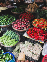 Fresh vegetables for sale at street food market in the old town of Hanoi, Vietnam. Garlic, Lemon, Ananas, Onions, Peper, Red chillies, carots
