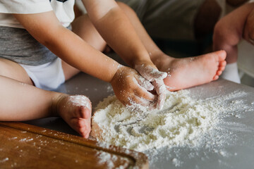 Obraz na płótnie Canvas Close up of a little boy's hand in flour in the kitchen.