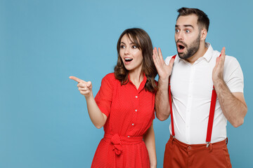 Shocked young couple two friends man woman in white red clothes point index finger aside spreading...