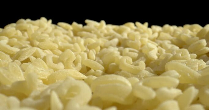 Alfabeto and alphabetti spaghetti macro shot. Raw Alphabet Pasta on black backround. Zoom out. High quality.