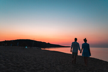 Silhouette of men and women at the beach at sunset