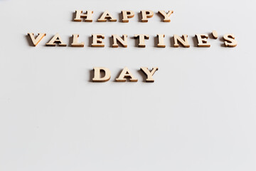 Happy Valentine's Day spelled with wooden letters on white background.