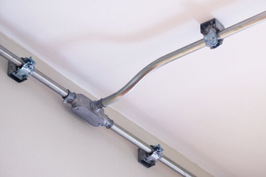 Steel conduit box to separate metal electrical pipe to different ways, installed on the wall and ceiling