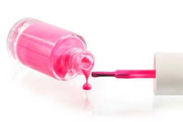 Pink nail polish pouring from a bottle isolated on a white background. Clipping path included 