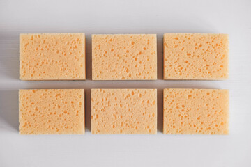 Yellow porous sponges on a white background. Top view. Copy, empty space for text