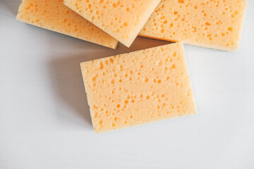 Yellow porous sponges on a white background. Copy, empty space for text