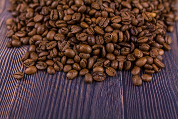 many coffee beans lie on a wooden table