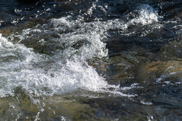 Gebirgsbach mit klarem Wasser in Bewegung