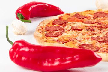 fresh aromatic hot italian pepperoni pizza with mozzarella cheese, red peppers and mushrooms on a white wooden table background