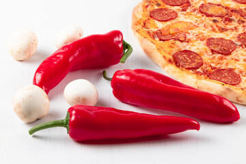 fresh aromatic hot italian pepperoni pizza with mozzarella cheese, red peppers and mushrooms on a white wooden table background
