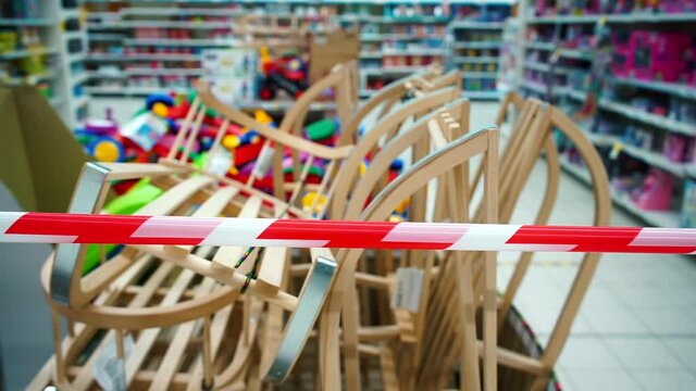 Product for sale in a store behind a red and white prohibition tape. Wooden children's sleds for snow. Frame is made of laminated beech wood from sustainable, environmentally compatible forestry. 