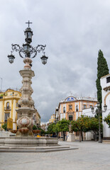 Fototapeta na wymiar town square and historic fountain and buildings in the historic old city of Seville