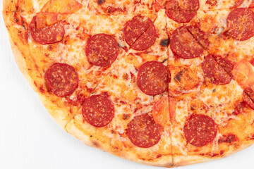 fresh aromatic hot italian pepperoni pizza with mozzarella cheese on white wooden table background