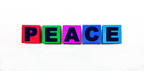 The word PEACE is written on colorful cubes on a light background