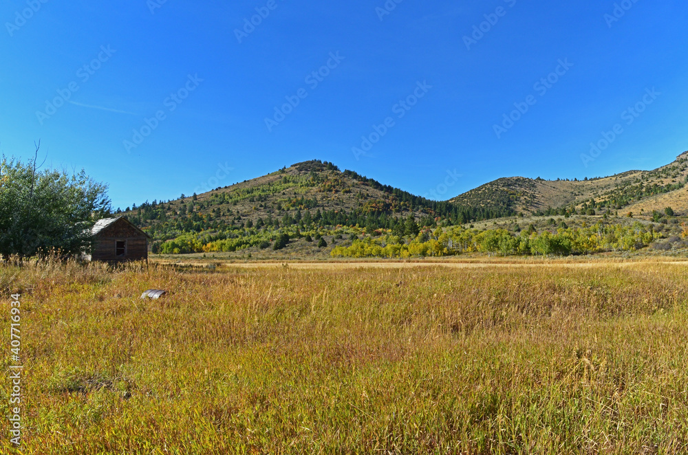 Poster mesmerizing shot of a mountainous area and an agricultural field under the blue sky